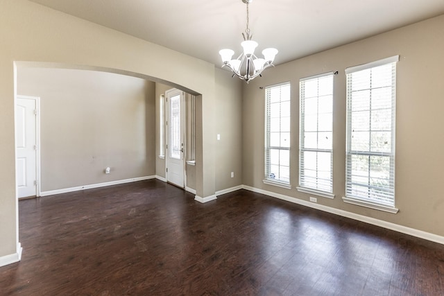 3713 Daisy Ln, Huntsville, TX 77340 - interior space featuring arched walkways, a notable chandelier, dark wood-type flooring, and baseboards