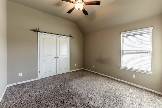 3713 Daisy Ln, Huntsville, TX 77340 - unfurnished bedroom with vaulted ceiling, carpet floors, a ceiling fan, and baseboards