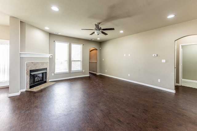 3713 Daisy Ln, Huntsville, TX 77340 - unfurnished living room with recessed lighting, ceiling fan, arched walkways, and a tiled fireplace