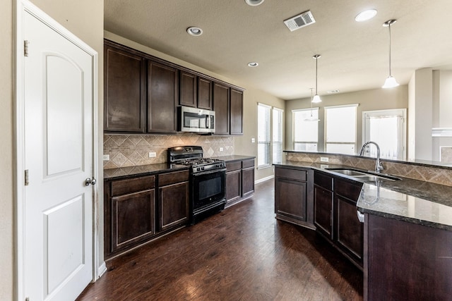 3713 Daisy Ln, Huntsville, TX 77340 - kitchen featuring backsplash, visible vents, a sink, stainless steel microwave, and gas stove