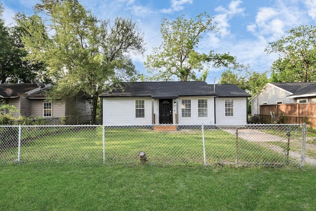 view of front of house featuring fence private yard and a front lawn