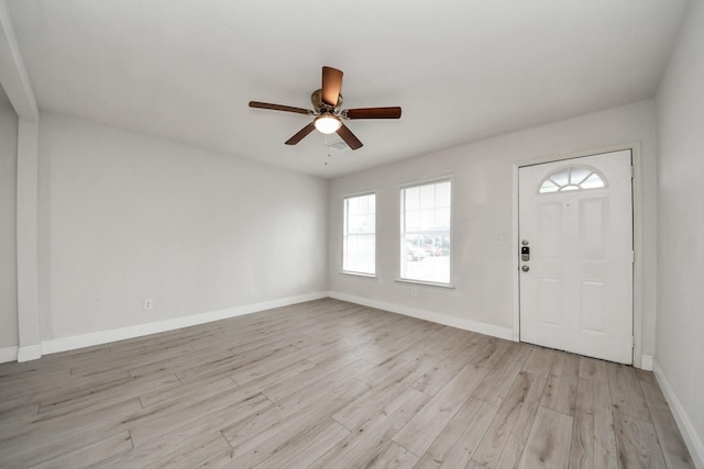 entryway featuring baseboards, a ceiling fan, and light wood-style flooring