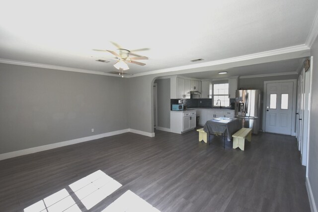 504 Cedar St, Sweeny, TX 77480 - unfurnished living room featuring a ceiling fan, a sink, arched walkways, baseboards, and ornamental molding