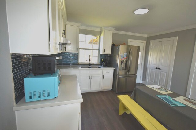 504 Cedar St, Sweeny, TX 77480 - kitchen featuring white microwave, stainless steel fridge, a sink, decorative backsplash, and white cabinets