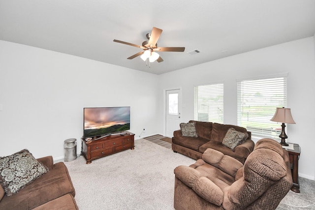 living area featuring carpet floors, a ceiling fan, visible vents, and baseboards
