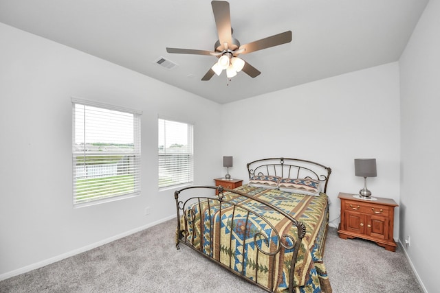 carpeted bedroom with baseboards, a ceiling fan, and visible vents