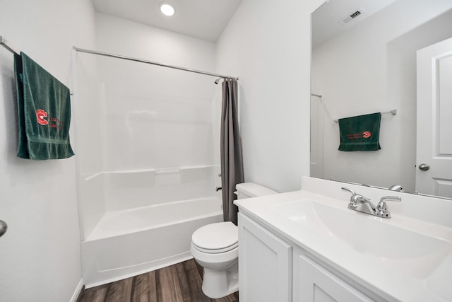 full bathroom featuring wood finished floors, visible vents, toilet, vanity, and shower / tub combo with curtain