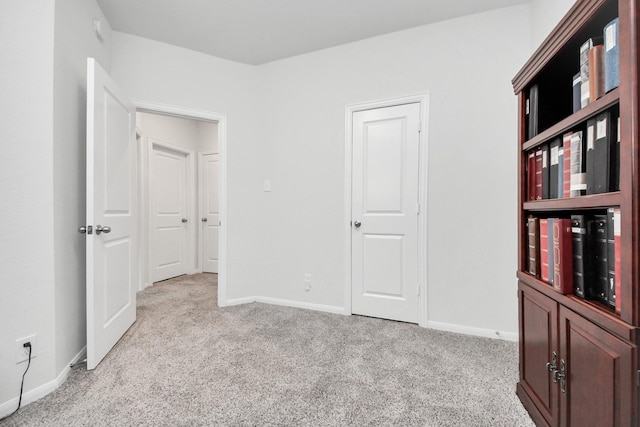 unfurnished bedroom featuring baseboards and carpet