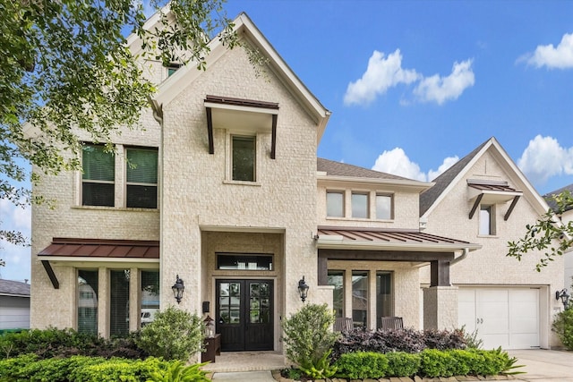 6605 Rolla St, Houston, TX 77055 - view of front of property featuring a standing seam roof, brick siding, a garage, french doors, and concrete driveway