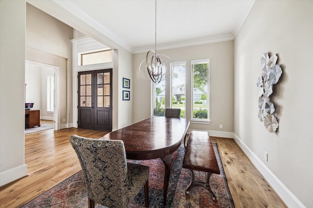 6605 Rolla St, Houston, TX 77055 - dining room with a chandelier, crown molding, light wood finished floors, and baseboards