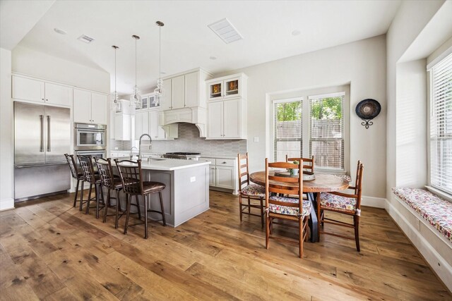 6605 Rolla St, Houston, TX 77055 - kitchen with an island with sink, hardwood / wood-style floors, stainless steel appliances, a kitchen bar, and a sink