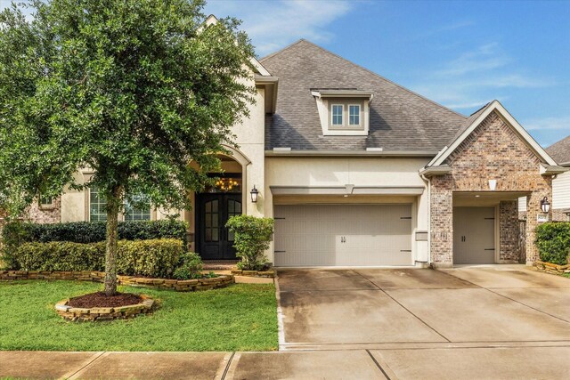 8207 Mesquite Hill Ln, Richmond, TX 77469 - view of front of house with driveway, a front yard, a garage, brick siding, and stucco siding