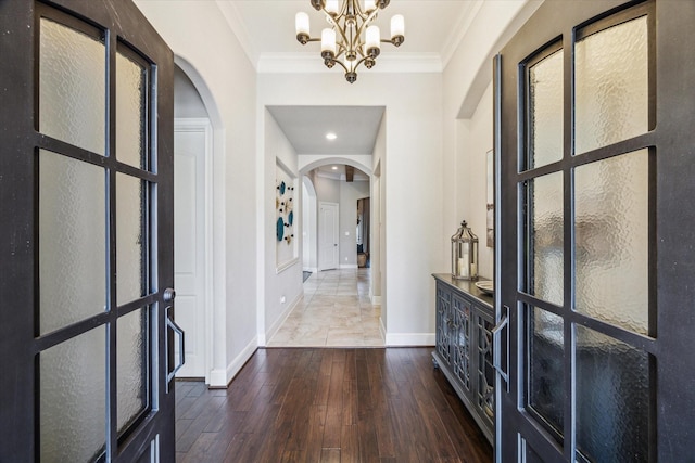 8207 Mesquite Hill Ln, Richmond, TX 77469 - foyer featuring crown molding, arched walkways, a chandelier, baseboards, and hardwood / wood-style flooring