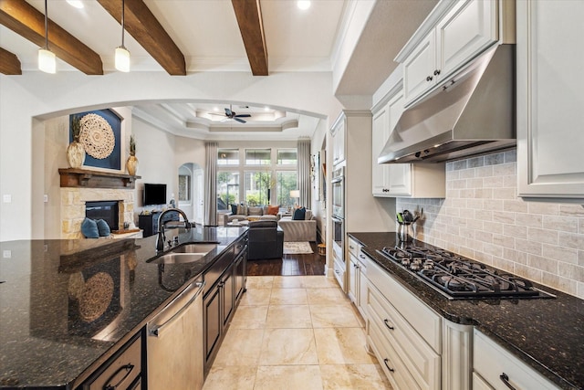 8207 Mesquite Hill Ln, Richmond, TX 77469 - kitchen featuring open floor plan, arched walkways, under cabinet range hood, a sink, and stainless steel appliances