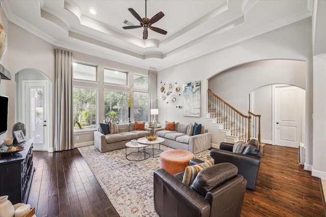 8207 Mesquite Hill Ln, Richmond, TX 77469 - living area with a ceiling fan, dark wood-style flooring, crown molding, arched walkways, and a tray ceiling