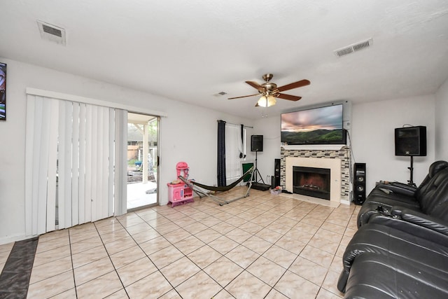 living room with light tile patterned floors, visible vents, a fireplace, and ceiling fan