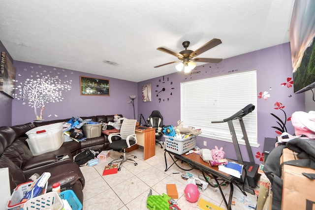 living area with tile patterned flooring, visible vents, and a ceiling fan