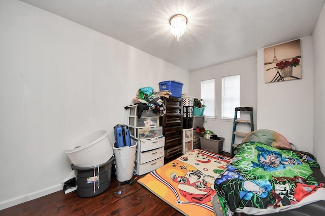 bedroom featuring baseboards and wood finished floors