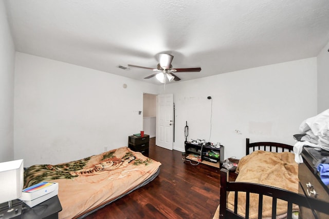 bedroom with ceiling fan, wood finished floors, and visible vents
