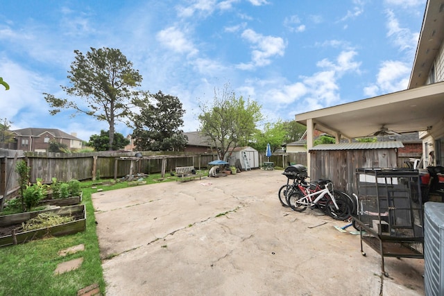 view of patio with a fenced backyard, a garden, an outbuilding, and a shed