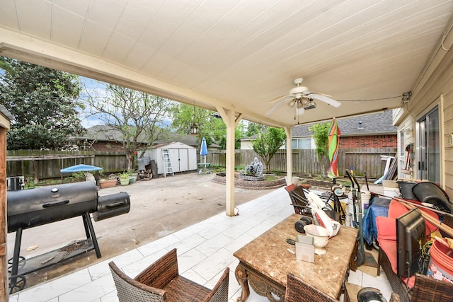 view of patio / terrace featuring a fenced backyard, an outbuilding, a storage unit, and outdoor dining area