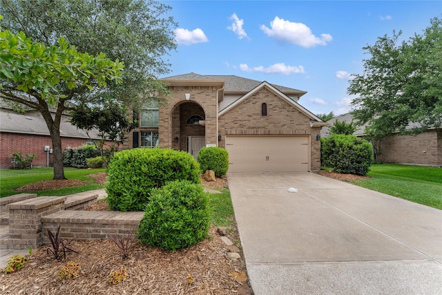 traditional-style house featuring a garage, brick siding, a front yard, and concrete driveway