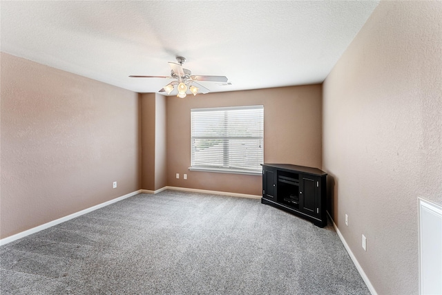 empty room featuring baseboards, a ceiling fan, and carpet