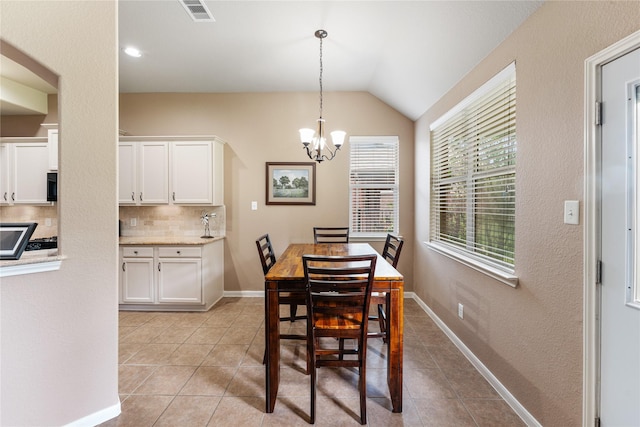 dining space with lofted ceiling, visible vents, a notable chandelier, and light tile patterned flooring