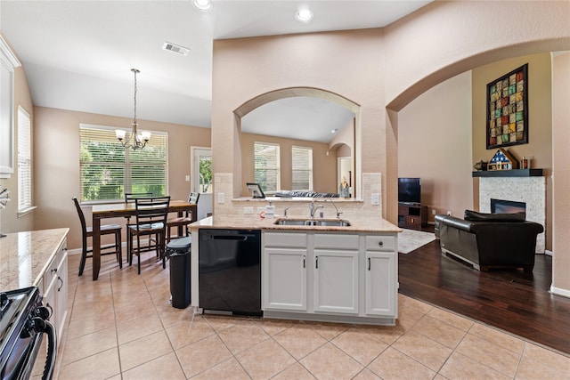 kitchen with visible vents, a sink, arched walkways, gas stove, and black dishwasher