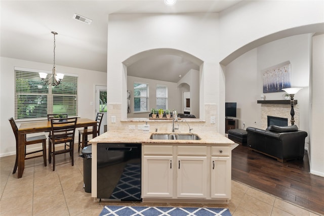 18823 Cove Mill Ln, Cypress, TX 77433 - kitchen featuring black dishwasher, light tile patterned flooring, a chandelier, light stone counters, and plenty of natural light