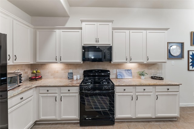 18823 Cove Mill Ln, Cypress, TX 77433 - kitchen with black appliances, decorative backsplash, white cabinets, and light stone countertops