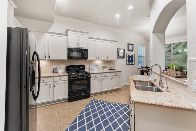 18823 Cove Mill Ln, Cypress, TX 77433 - kitchen with black appliances, tasteful backsplash, light tile patterned floors, white cabinetry, and light stone counters