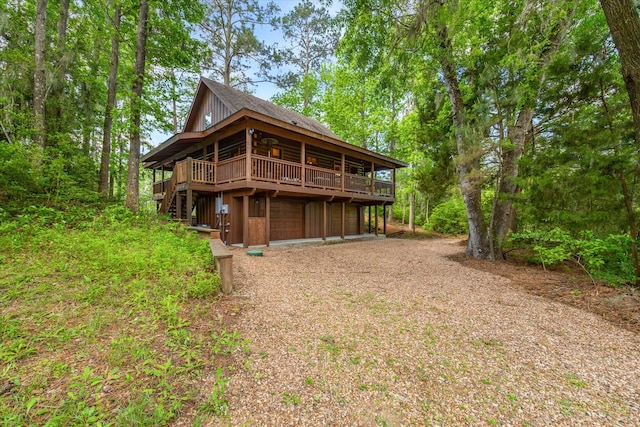 65 Artesian Ave, Cleveland, TX 77327 - back of house featuring a deck, dirt driveway, and an attached garage