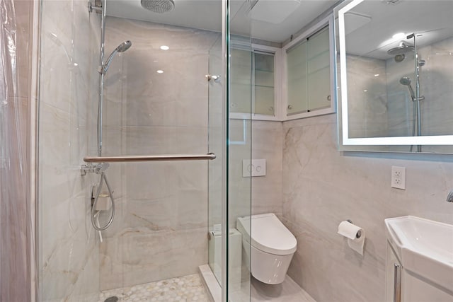 full bath featuring toilet, vanity, a marble finish shower, and tile walls