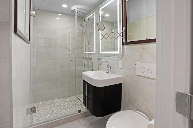 bathroom featuring a stall shower, vanity, tile walls, toilet, and recessed lighting