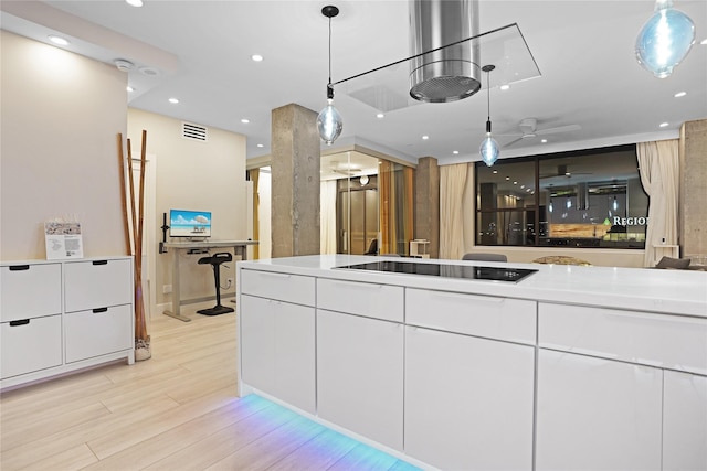 kitchen with white cabinets, visible vents, light wood-type flooring, decorative light fixtures, and black electric stovetop