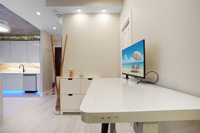 office area with recessed lighting, light wood-style flooring, and a sink