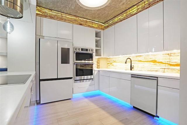 kitchen featuring white cabinets, modern cabinets, dishwashing machine, white refrigerator, and double oven