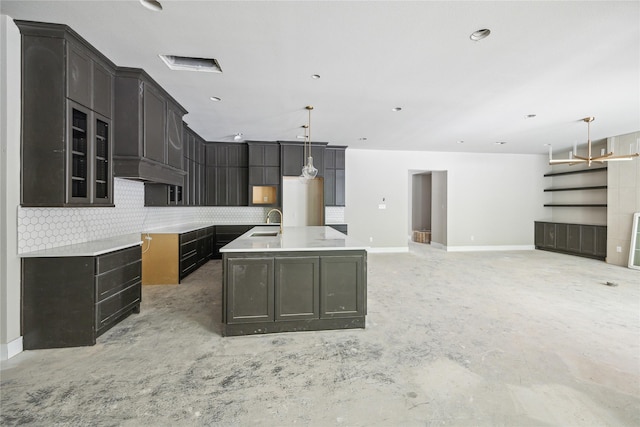 kitchen with decorative backsplash, baseboards, a sink, and unfinished concrete flooring