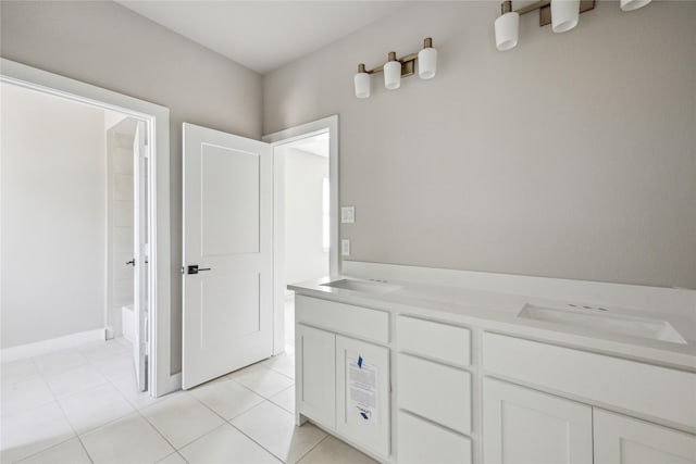 bathroom with a tub to relax in, tile patterned flooring, a sink, and double vanity