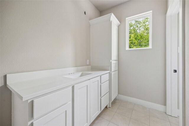 bathroom with tile patterned flooring, baseboards, and a sink