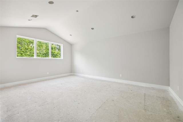 spare room with vaulted ceiling and baseboards
