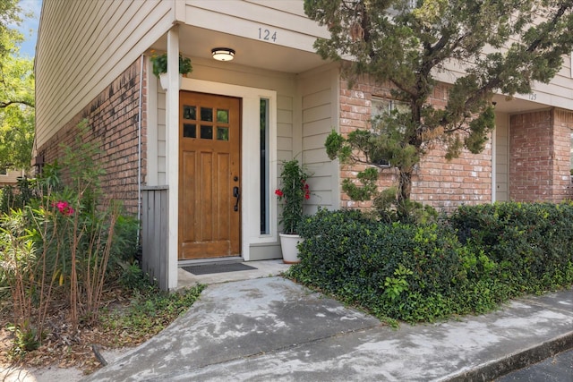 property entrance featuring brick siding
