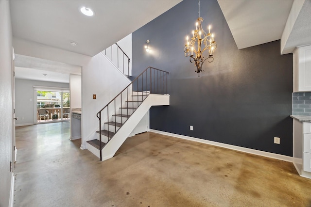 stairs featuring baseboards, finished concrete floors, and a chandelier