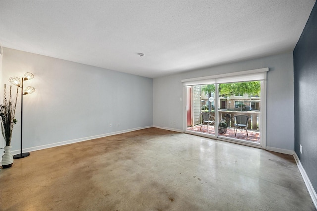 unfurnished room featuring concrete floors and baseboards