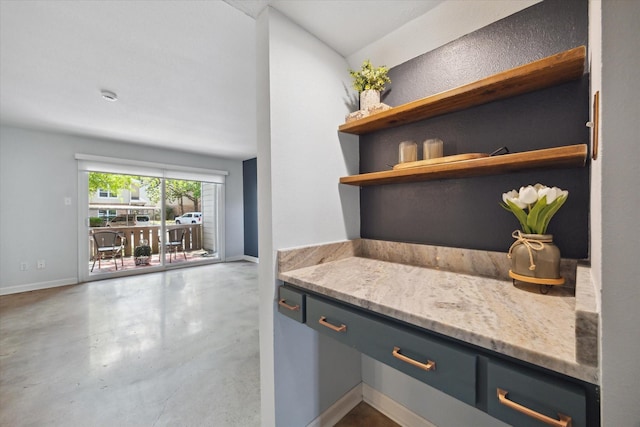bar featuring finished concrete flooring and baseboards