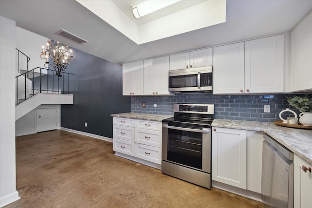 kitchen with backsplash, visible vents, concrete floors, appliances with stainless steel finishes, and white cabinetry