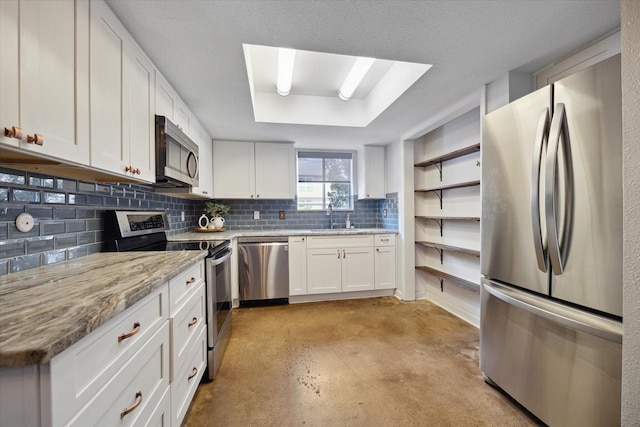 kitchen with white cabinets, a sink, backsplash, open shelves, and appliances with stainless steel finishes