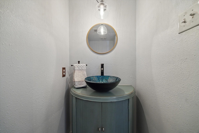interior details featuring a textured wall and vanity