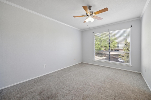 carpeted empty room featuring a ceiling fan, baseboards, and ornamental molding